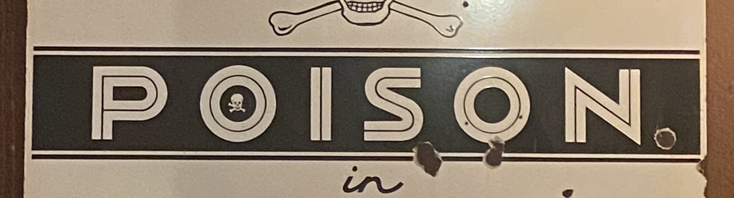 A banner image which shows an old sign that says Poison.